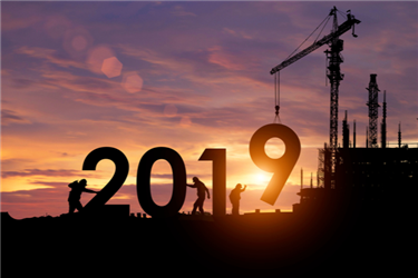 Construction team putting 2019 in place with sunrise as backdrop