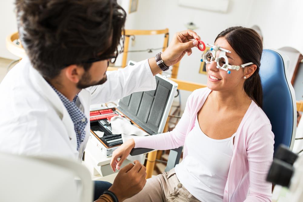 optometrist conducting an eye test on adult patient