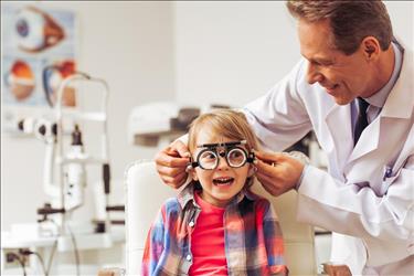 optometrist conducting an eye test on child patient