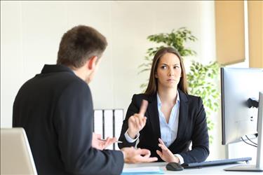 Boss waving finger at employee