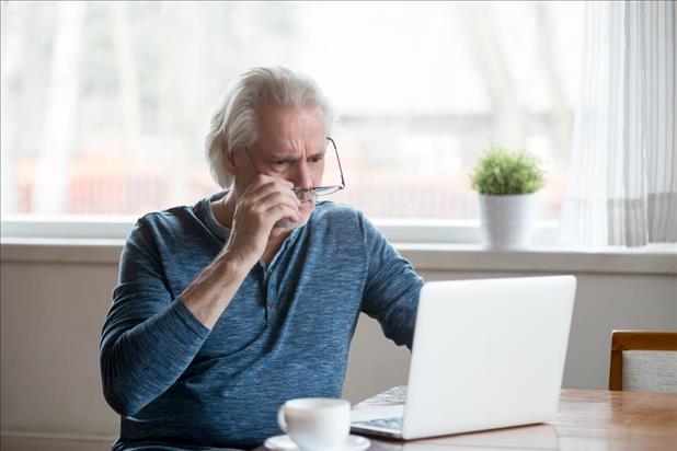 Man looking skepitcally at laptop