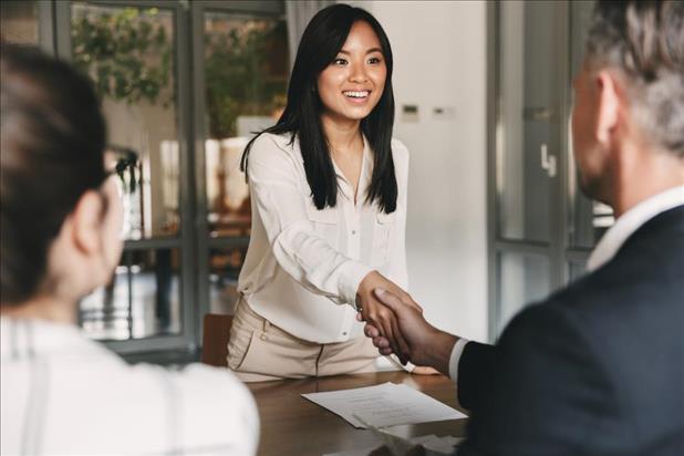 Woman shaking interviewer's hand and smiling