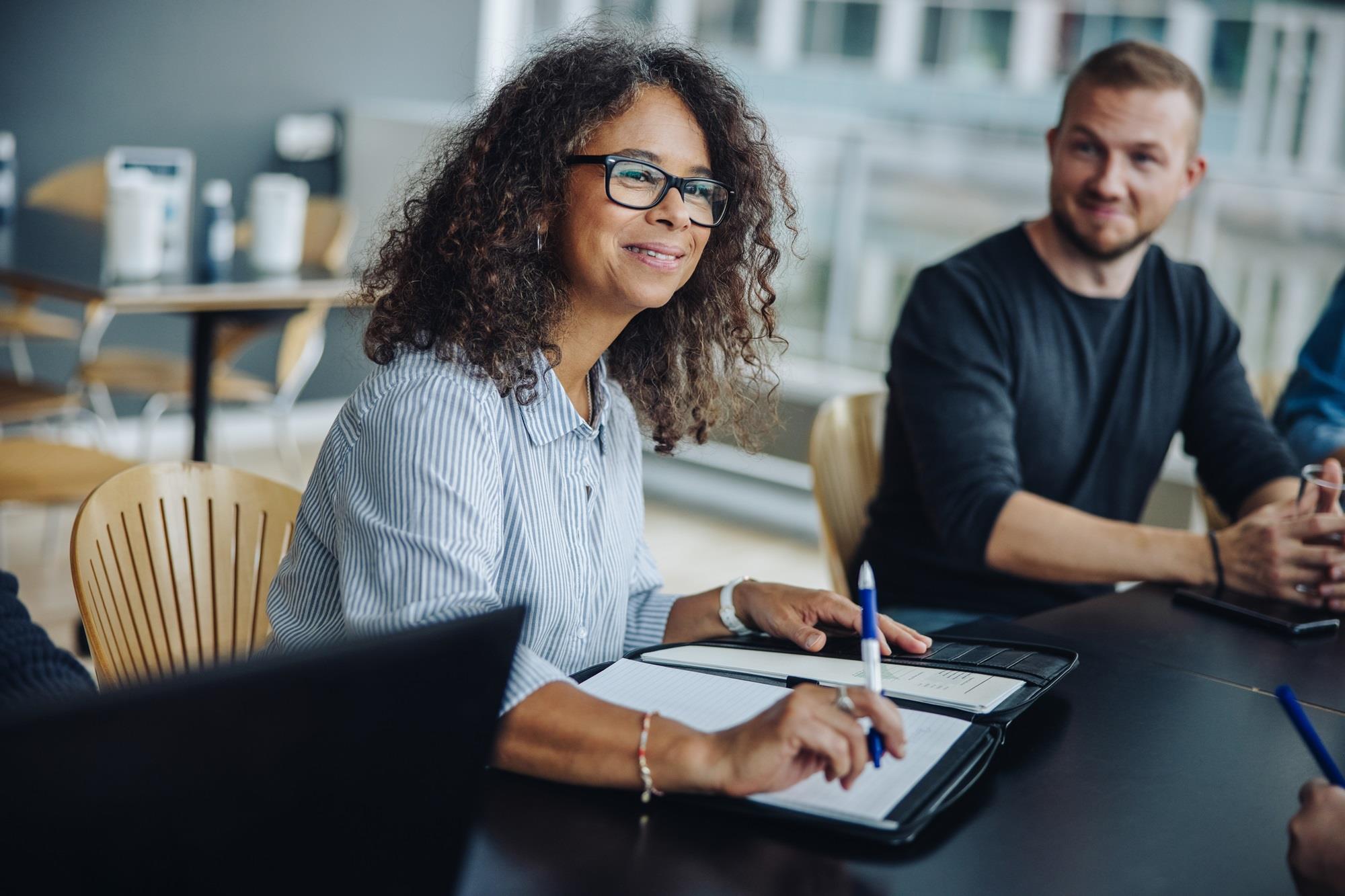 employee in a meeting with a notebook in front of her