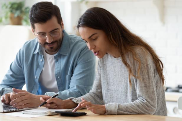 employees looking at tax forms with calculator