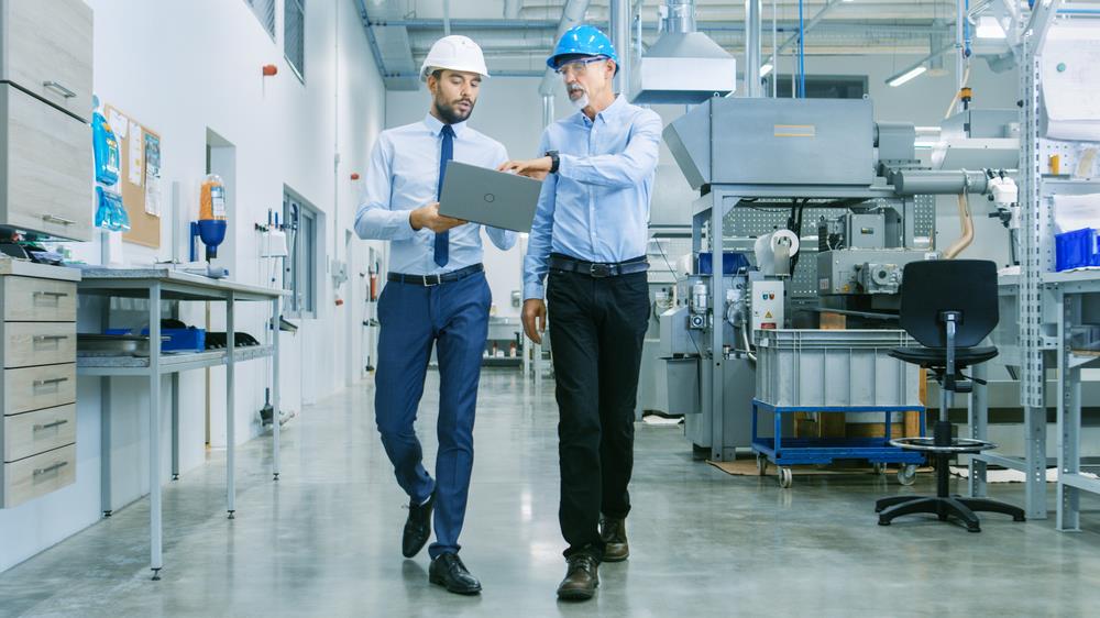 Engineer and plant manager walking through modern manufacturing facility