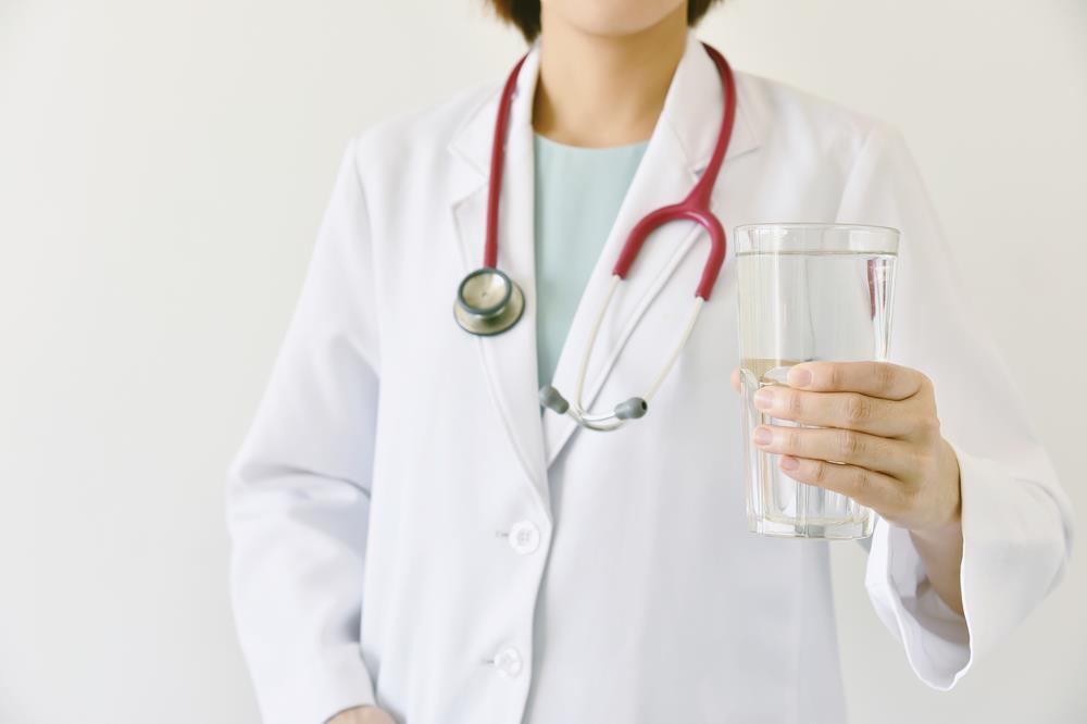 nurse holding up a glass of water