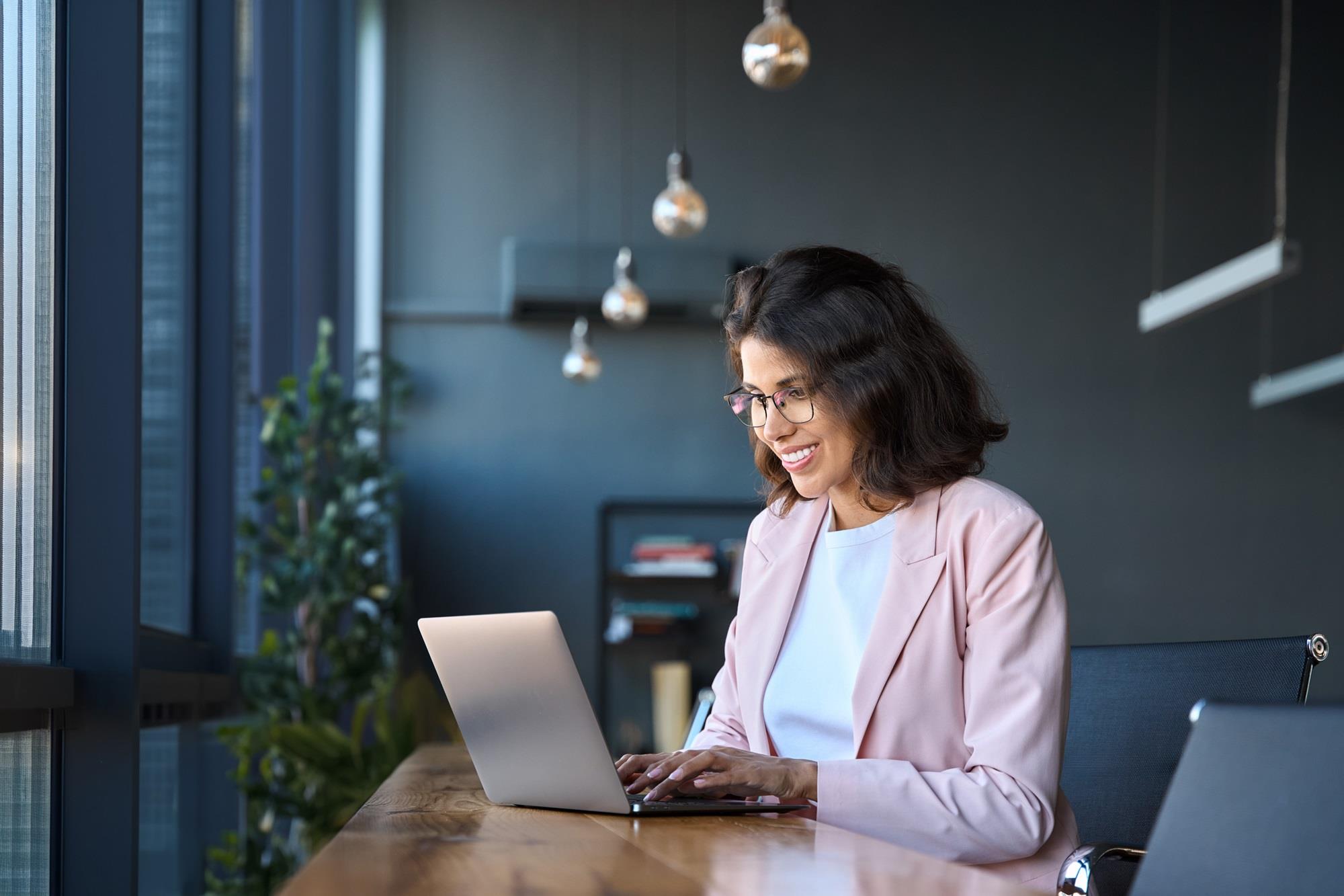 smiling job seeker working on her laptop