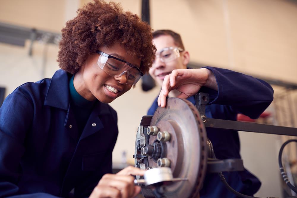 Automotive apprentice checking brakes