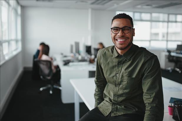 smiling young professional sitting over his desk