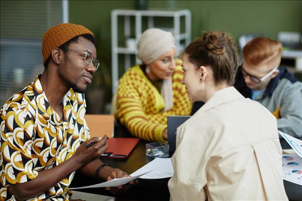 young african american man collaborating with team in business meeting