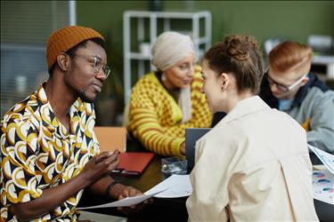 young african american man collaborating with team in business meeting