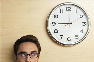 Job seeker looking at clock and thinking about what they can get done in an hour