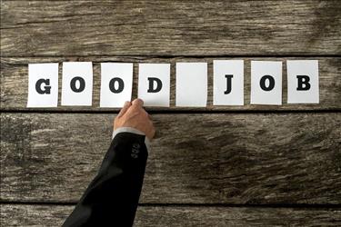 employer putting "good job" sign on wall