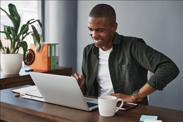 happy job seeker looking at his laptop